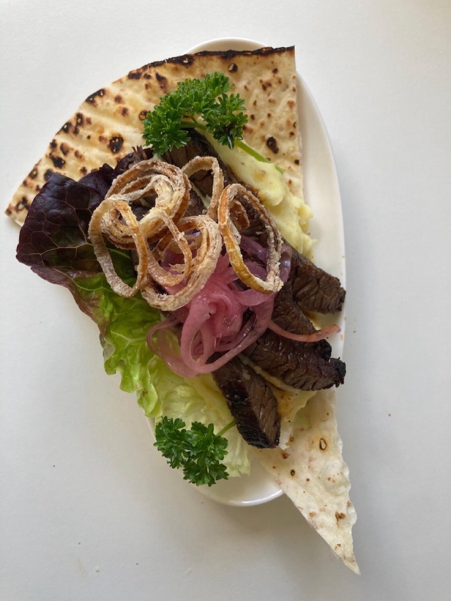 Mjukt tunnbröd med grillad biff, picklad rödlök, friterad schalottenlök och potatismos